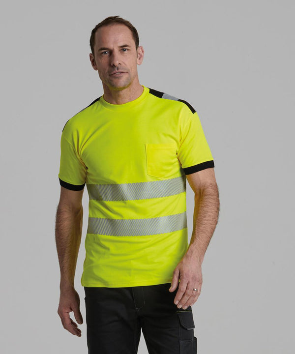 A man wearing the Portwest PW3 Hi-vis t-shirt (T181) in yellow with reflective silver stripes, black sleeve and shoulder trim, and black trousers stands against a plain grey background.