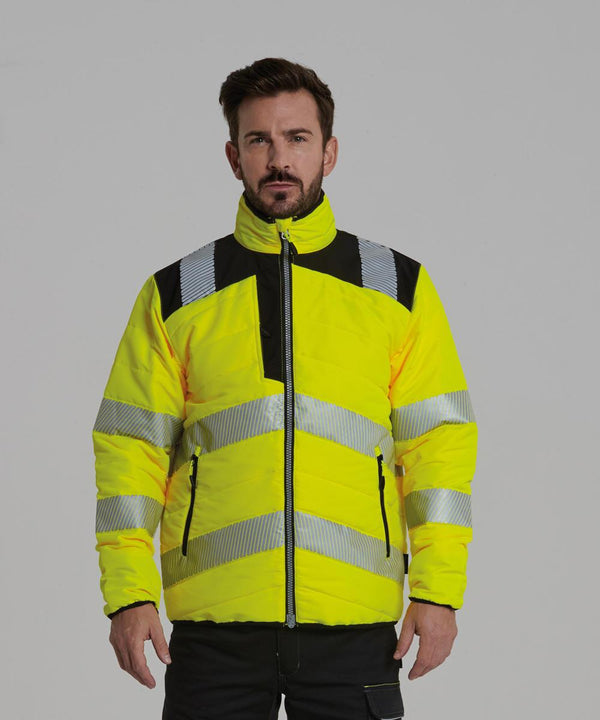 A man stands facing forward wearing the Portwest PW3 Hi-vis baffle jacket (PW371), a bright yellow high-visibility jacket with reflective silver stripes and black accents, zipped up with his hands by his sides against a plain background.