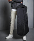 Person in beige pants, white sneakers, and a gray jacket holding a Quadra QD031.