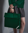 Person holding a large Quadra QD051 against their leg, wearing a green cardigan and grey skirt.