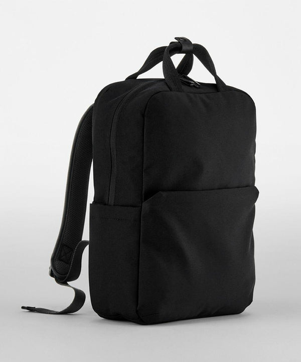 A black backpack with a minimalist design featuring a large front pocket and a small side pocket. It has adjustable shoulder straps and a top handle. The backpack is the QD271 by Quadra.