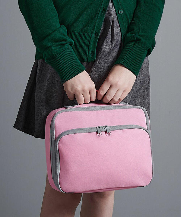 Person holding a pink Quadra QD435 with gray trim, dressed in a green sweater and gray skirt, standing against a plain background.