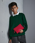 A young boy in a green long-sleeve shirt and white collar holds a Quadra QD442, standing against a gray textured wall.