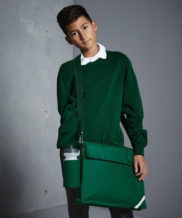 A young person in a green sweater and white collared shirt stands against a plain background, holding a Quadra QD457 bag with an attached water bottle.