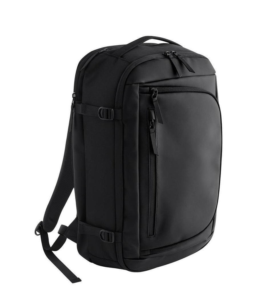 The Bags rucksack in black features a minimalist design with a top handle, side compression straps, and multiple zipped compartments, displayed on a plain white background.