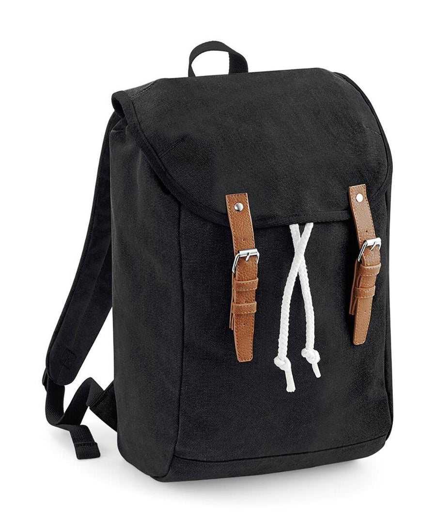 The QD615 by Quadra is a black canvas backpack featuring a flap closure, brown leather straps, and white drawstrings.