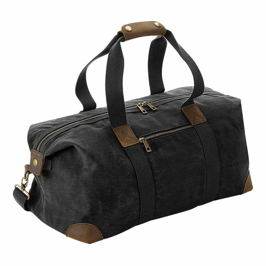 The Quadra QD650 is a black canvas duffel bag featuring brown leather accents and two zippered compartments.
