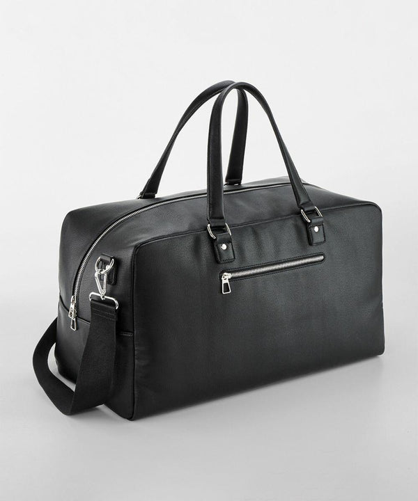 Quadra's QD778 black leather duffel bag with two top handles, a shoulder strap, and a front zip pocket on a light gray background.