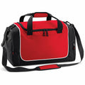 The Quadra QS077 is a red and black duffel bag with a spacious front pocket, black handles, and an adjustable shoulder strap. It also features white piping accents and side mesh pockets.