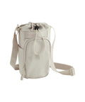 The Bags crossbody is a small beige bag featuring a front zippered pocket, adjustable shoulder strap, and drawstring top fastening. It’s shown against a white background.