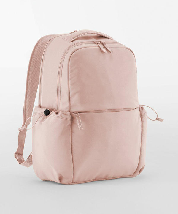 A light pink Quadra QS306 with a large main compartment, a front zippered pocket, two side pockets, and padded shoulder straps.