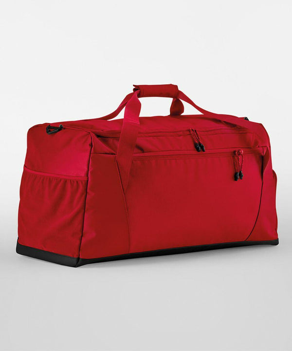 A Quadra QS470 with a zippered pocket on the front, two side pockets, and red carrying handles, placed against a plain white background.