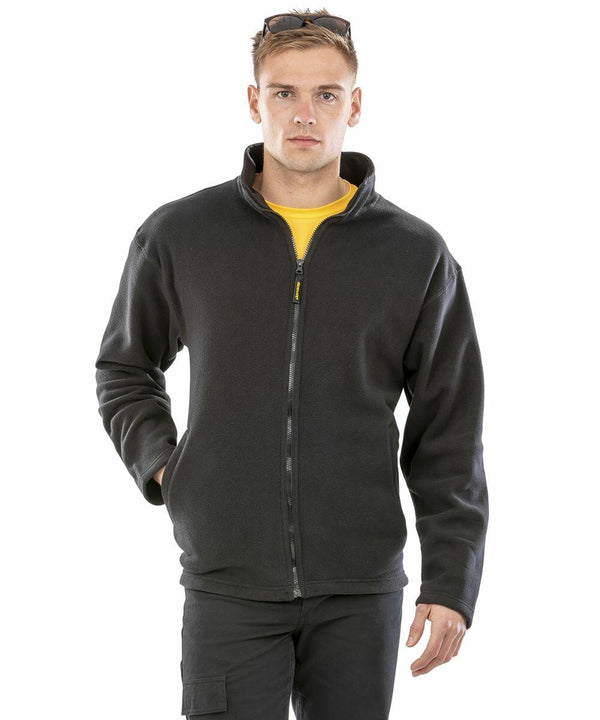 A man wearing a black Result R115A jacket over a yellow shirt, with sunglasses resting on his head, stands against a plain white background.