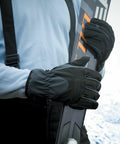 A person wearing black gloves and a blue long-sleeve shirt holds a pair of Result R134X skis upright against their body.