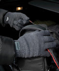 A person wearing gray gloves zips up a black Result R147X.