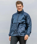 A man wearing a blue Result R204X jacket stands outdoors against a cloudy sky, looking at the camera.