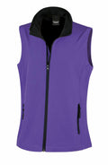 Product Description: A sleeveless vest from Result Core, model R232F, featuring a stylish purple color with a front zipper and two zippered pockets. The design includes a black turned-up collar. The vest is showcased against a simple white backdrop.