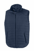 The R239X by Result Genuine Recycled is a navy blue, quilted, sleeveless puffer vest featuring a full zip closure down the center and two zippered pockets on either side. This vest includes a high collar and boasts a sleek, padded design, making it perfect for layering in cooler weather.