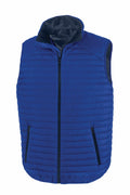The Result Genuine Recycled R239X vest is a blue, sleeveless quilted piece with a front zipper and two zippered pockets. It showcases horizontal stitching and a high collar, offering a casual yet functional outerwear option.