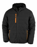 Introducing the R240X by Result Genuine Recycled: a stylish black puffer jacket featuring a hood and orange zipper accents. The jacket boasts an eye-catching quilted look with vertical and horizontal stitch patterns. It is designed with two zippered side pockets and a front zipper for added style and functionality.