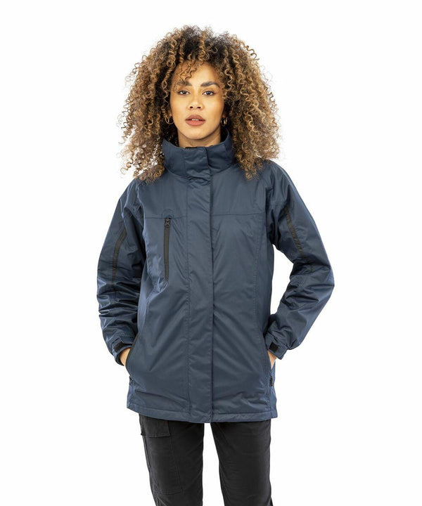 A person stands wearing a dark blue Result R400F jacket with hands in pockets against a white background.