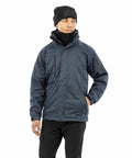 Person wearing a dark blue Result R400M jacket, black beanie, and a black scarf, standing with one hand in a pocket and looking to the side.