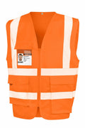 The R477X safety vest by Result Safeguard is orange with white reflective stripes, multiple pockets, and includes an ID badge attached to the chest.