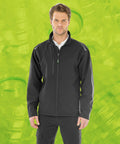 A man wearing a Result R900X and black pants stands against a lime green background with a pattern of plastic bottles.