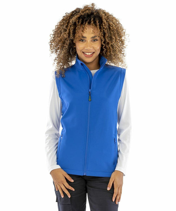 A person with curly hair is wearing a bright blue Result R902F zip-up vest over a white long-sleeve shirt.