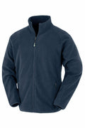 The Result Genuine Recycled R903X is a navy blue fleece jacket that includes a full front zipper and a high collar. It has long sleeves and two zippered pockets on each side, offering a soft and warm feel.