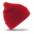 A vibrant red beanie from the Result Winter Essentials collection, model RC029, with a folded cuff is set against a white background. The beanie is positioned at a slight angle with a soft shadow beneath it.