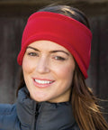 A person wearing a red RC140 headband from Result and a gray zip-up jacket smiles at the camera.