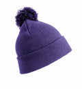 The RC28X by Result Winter Essentials is a purple beanie featuring a knitted design and a pom-pom on top, displayed against a white background. The folded brim adds to its cozy and stylish look.