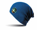 RC31X by Result Winter Essentials, a blue knit beanie featuring a circular logo patch on the side, set against a shadowed white background.