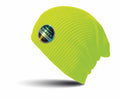 A knit beanie in a vibrant yellow-green shade, featuring a circular patch with the text "Softex" and vivid reflections, subtly casting its shadow on the surface below. This item is part of the RC31X collection from Result Winter Essentials.