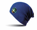The RC31X by Result Winter Essentials is a blue knit beanie with a ribbed texture. It has a round logo patch on the side featuring the name "Soft-Tex" accented with a colorful gradient. The beanie is showcased against a white background with a subtle shadow beneath it.