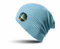 A light blue ribbed knit beanie, featuring a circular patch with the words SOFTEX and ABRAIDUR along with additional small text. This beanie is from Result Winter Essentials and is labeled as product RC31X. It is displayed against a white background.