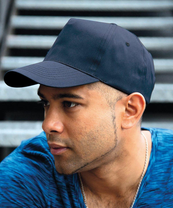 A person wearing a blue cap and blue shirt is looking to the side with stairs in the background, featuring the RC80X by Result.
