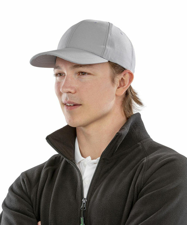 A person wearing a gray Result Genuine Recycled RC981 baseball cap and a dark zip-up jacket looks off to the side.