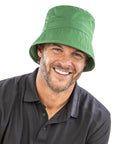A man in a Result Headwear Recycled bound edge bucket hat and a black polo shirt smiles at the camera against a plain white background.