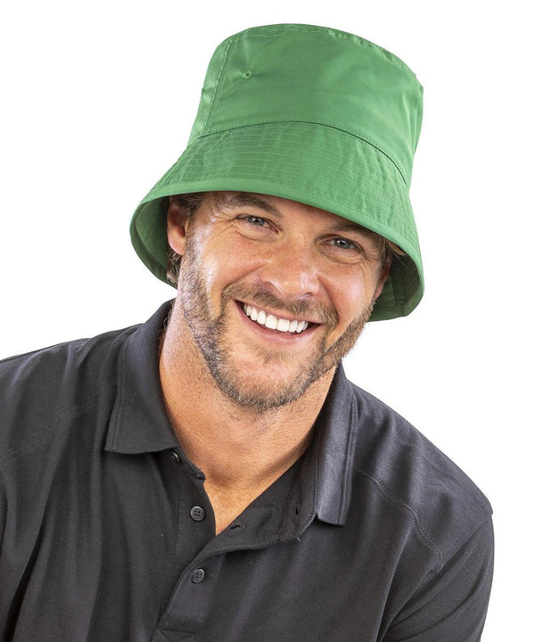 A man in a Result Headwear Recycled bound edge bucket hat and a black polo shirt smiles at the camera against a plain white background.