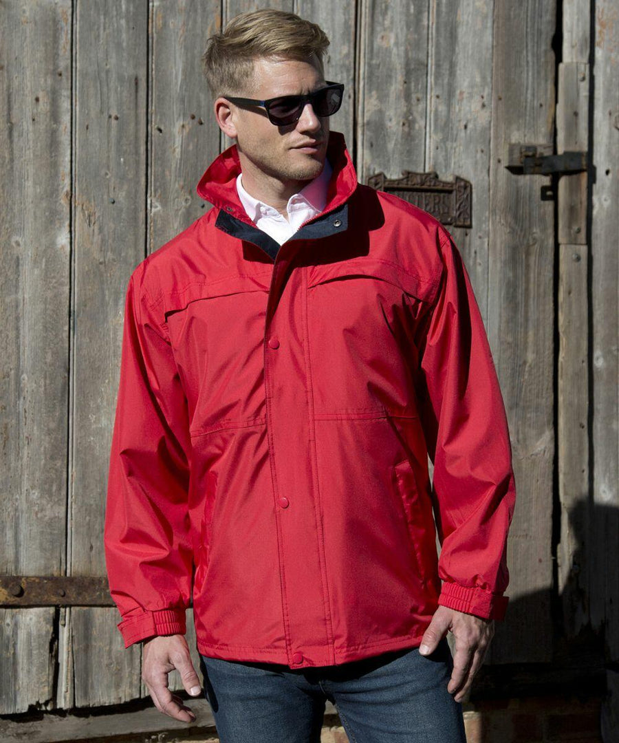 A man wearing Result's RE67A and a red jacket stands in front of a rustic wooden door.