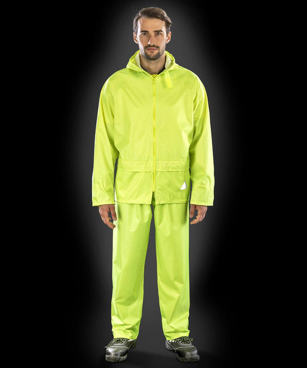 A person wearing a bright yellow Result RE95A raincoat and matching rain pants stands against a black background.