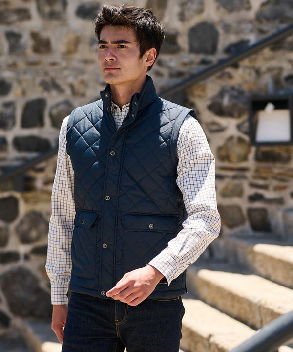 A man wearing a Regatta RG077 over a checkered shirt stands outside near stone steps.