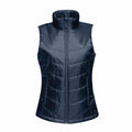 The RG114 vest by Regatta Professional features a navy blue puffer design with a high collar and front zipper, showcasing sleeveless construction and horizontal stitching details.