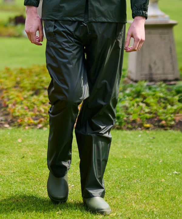 Person walking on grass wearing dark green RG205 waterproof pants by Regatta and green boots.