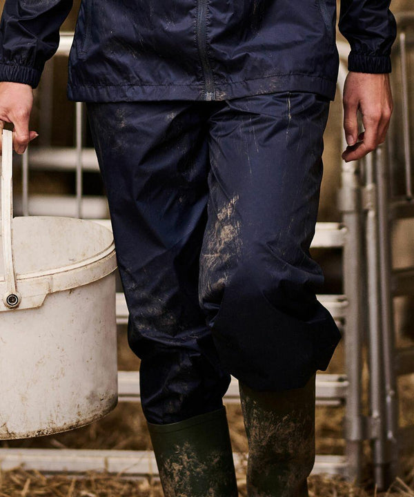 Person wearing a blue **Regatta RG315** rain suit and green boots, carrying a white bucket, with mud splattered on the clothing.