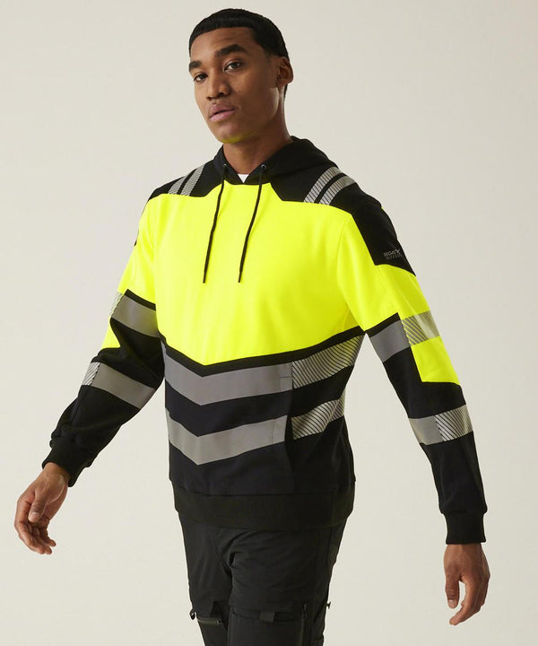 A man wears the Regatta High Visibility Hi-Vis X-Pro Hoodie (Class 2) in black and neon yellow with reflective grey stripes, standing against a plain background and facing slightly left with one arm extended.