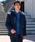 A man wearing a dark blue Regatta RG580 and light blue shirt walks outside near a set of stairs.