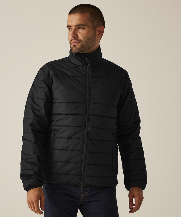A person wearing the Regatta Professional Essential thermal jacket in black and dark jeans stands against a plain, light background, gazing off to the side.
